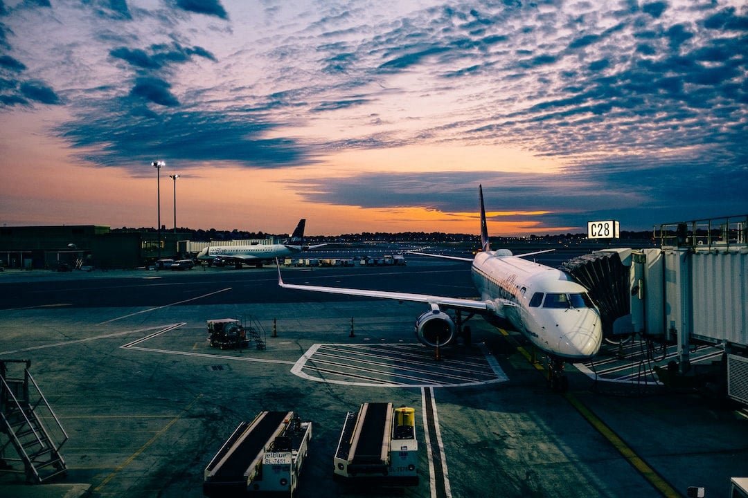 Passenger airplane waiting at an airport gate at sunset